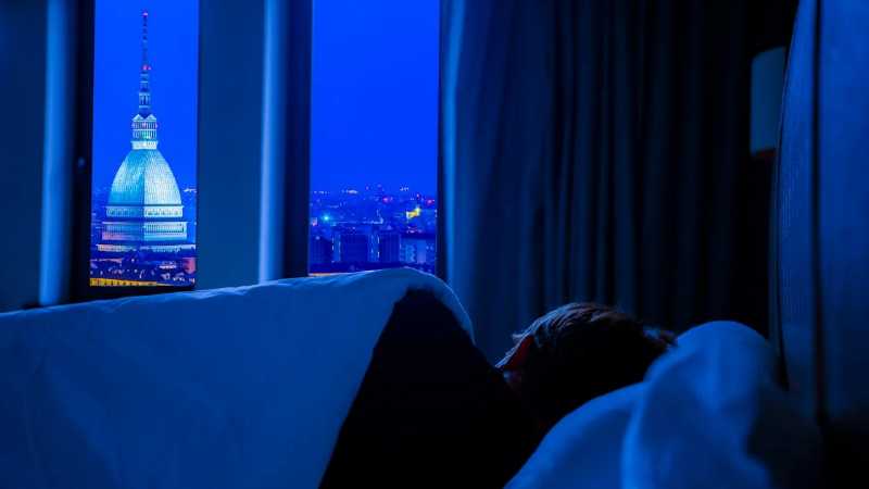 A serene view of Turin's night skyline featuring Mole Antonelliana, seen from a cozy bedroom., tags: und schlaf-tourismus einer - pexel